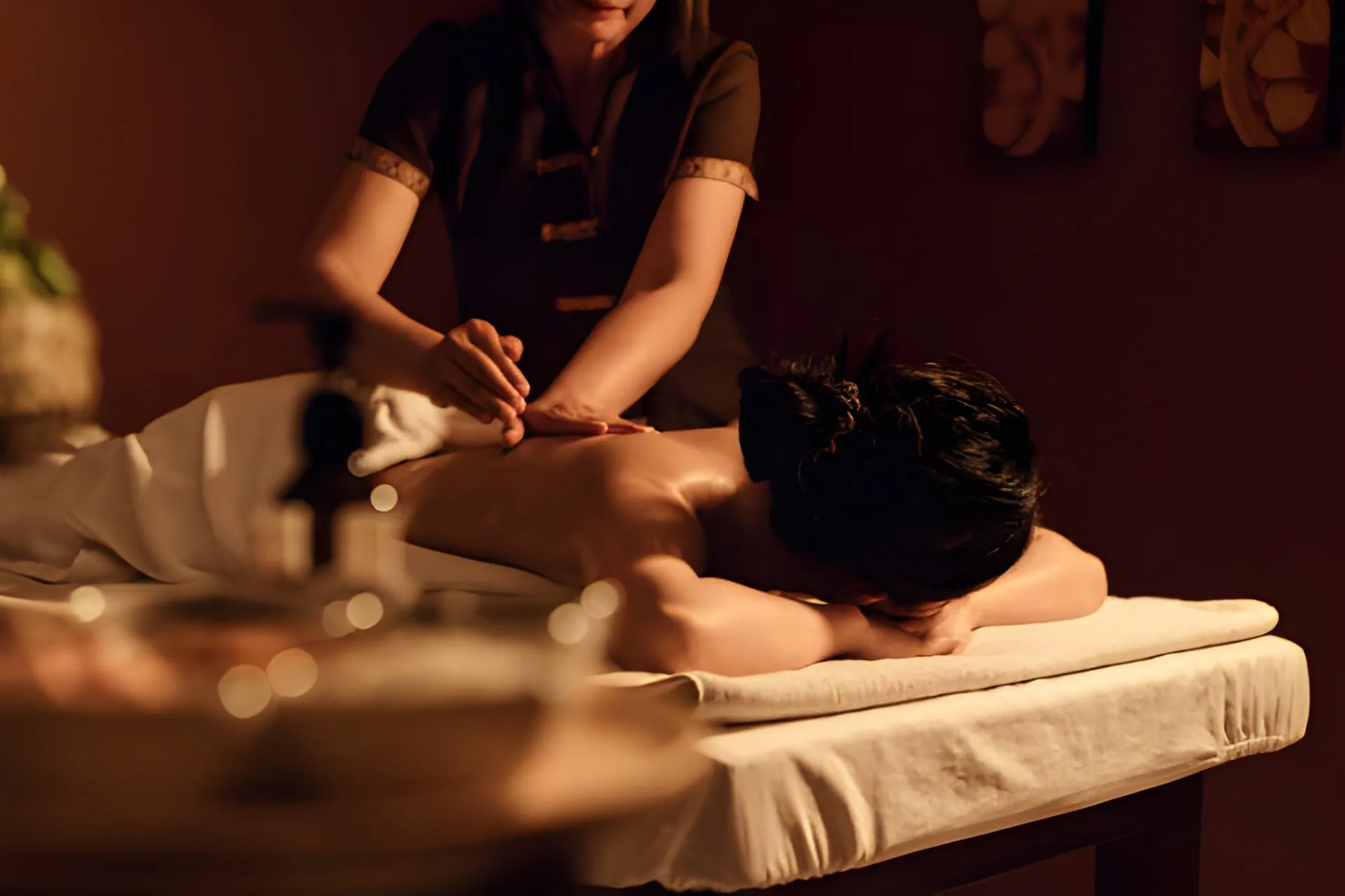 A serene image of a masseuse giving a relaxing back massage to a client lying on a massage table. The picture conveys the therapeutic benefits of a professional Massage Port St Lucie.
