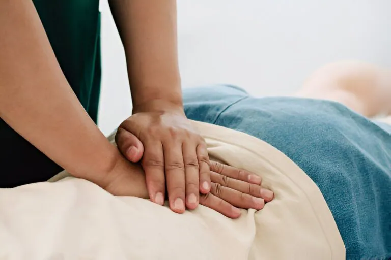 A close-up of a person receiving a therapeutic massage on their lower back, illustrating holistic and alternative approaches to Pain Management Port St Lucie.