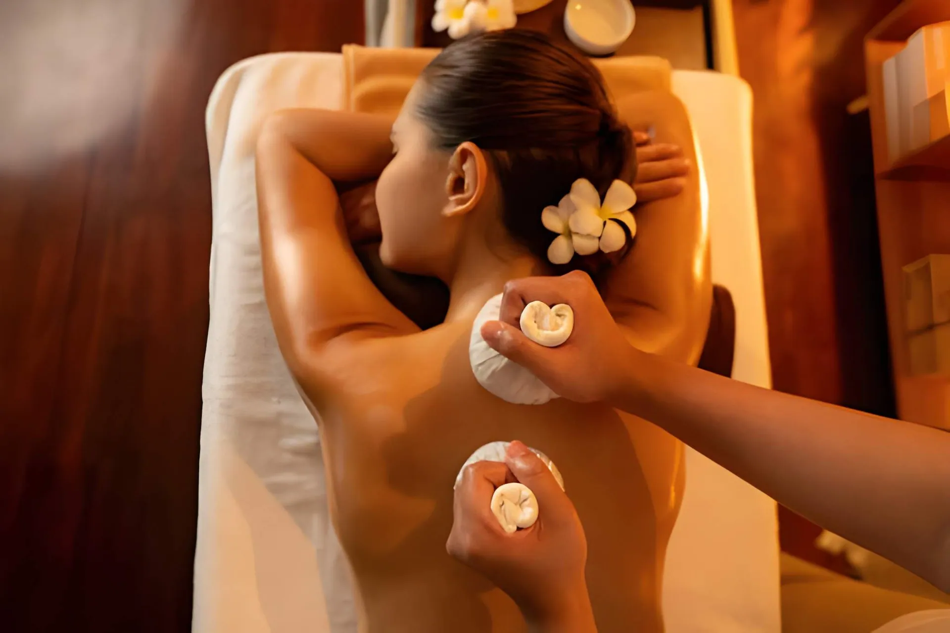 Herbal compress massage in serene spa—Port St Lucie massage therapy for relaxation and circulation