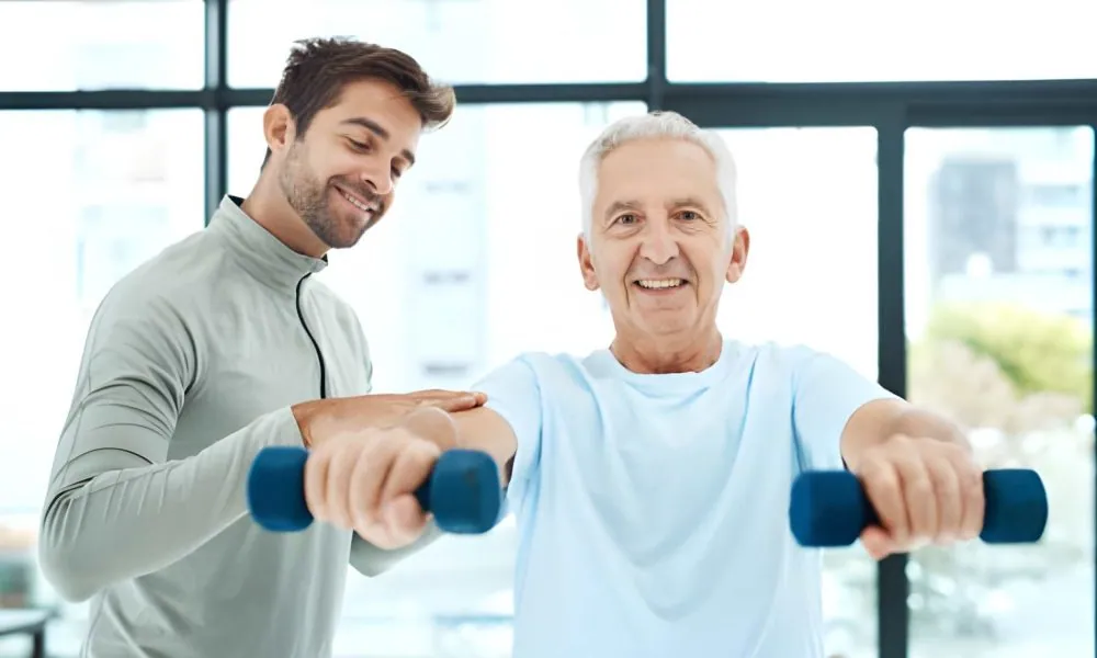 Chiropractor Fort Pierce guiding senior through shoulder-strengthening exercise with dumbbells in wellness center
