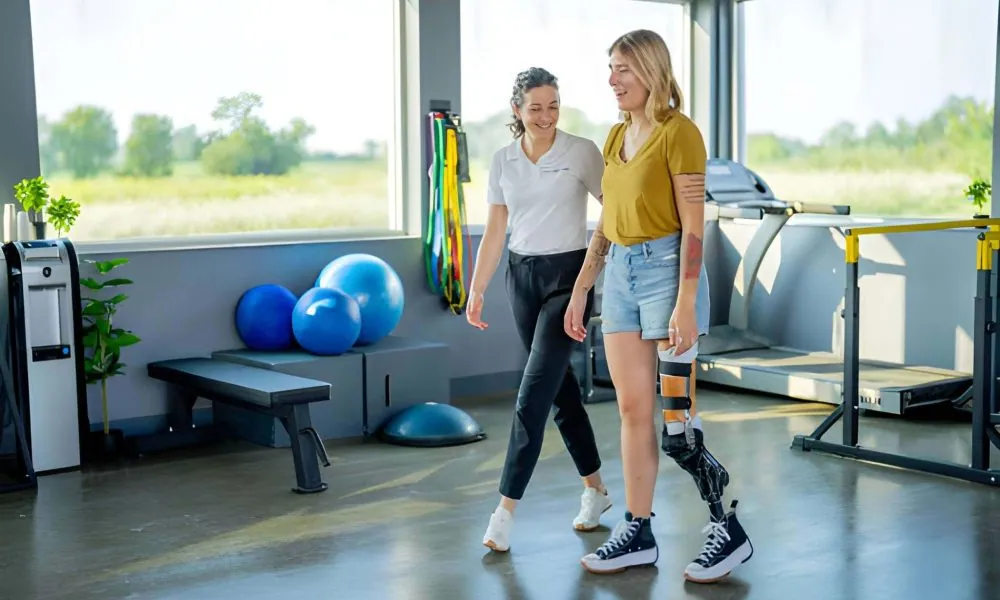Physical therapy Port St Lucie Florida—therapist assists patient with prosthetic leg during walking exercise.